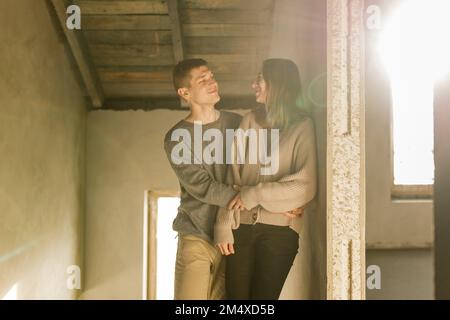 Smiling young couple looking at each other at home Stock Photo