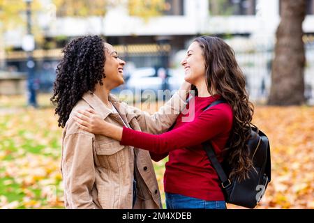 Happy friends talking in autumn park Stock Photo