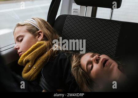 Girls sleeping together in car Stock Photo