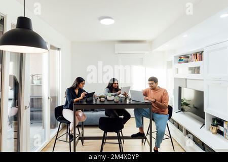 Young women and man studying through wireless technologies at home Stock Photo