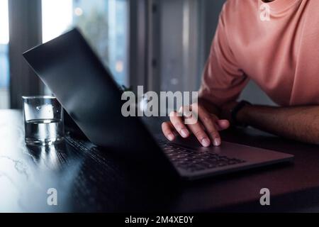 Hand of man using laptop on table at home Stock Photo