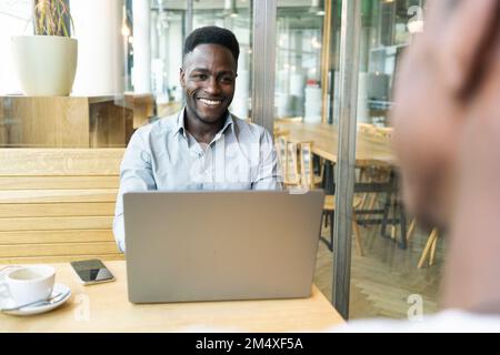 Happy businessman having meeting with customer in cafe Stock Photo