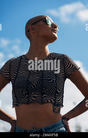 Woman with hand on hip standing in front of sky Stock Photo