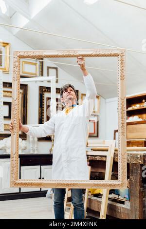 Woodworker working with frame in studio Stock Photo