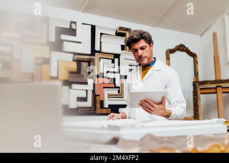 Mature craftsman using tablet PC in workshop Stock Photo