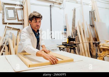 Craftsman making frame in workshop Stock Photo