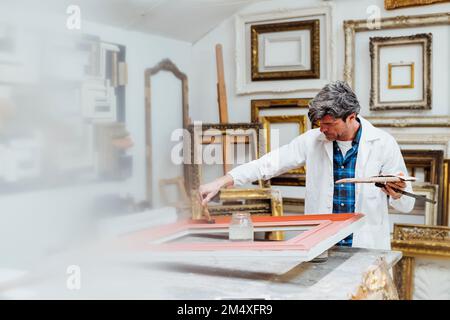 Craftsman polishing frame in workshop Stock Photo