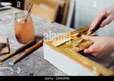 Craftsman with hand tool working on frame in workshop Stock Photo