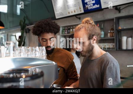Barista and colleague working in cafe Stock Photo