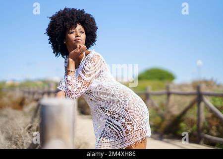 Thoughtful young woman leaning on wooden railing Stock Photo