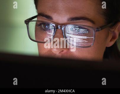 Computer programmer wearing eyeglasses looking at codes Stock Photo