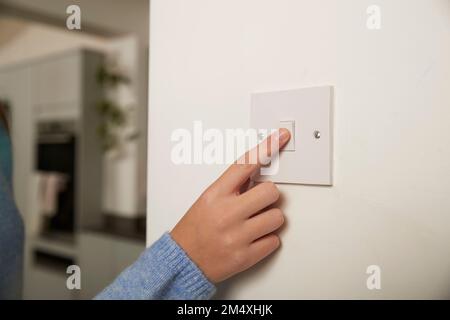 Finger of girl turning off switch at home Stock Photo