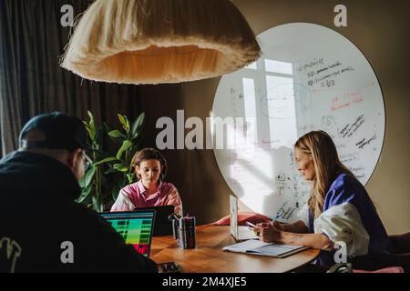 Woman with colleagues working at desk in conference room Stock Photo