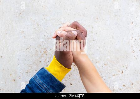 Man holding hand of woman in front of wall Stock Photo