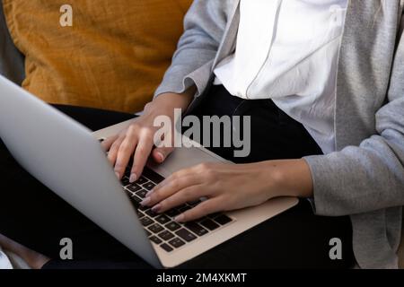 Young woman using laptop at home Stock Photo