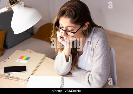 Young woman with book studying at home Stock Photo
