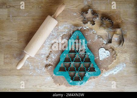 Christmas cookie mold by cutter and rolling pin with dough on table Stock Photo