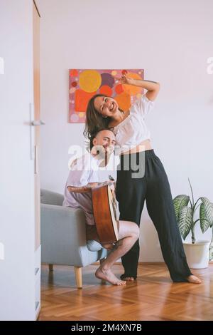 Cheerful couple having fun in living room at home Stock Photo
