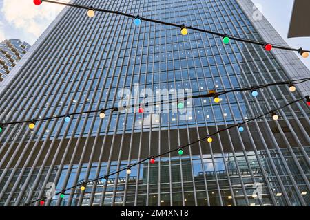 Multi colored light bulbs hanging in front of building Stock Photo