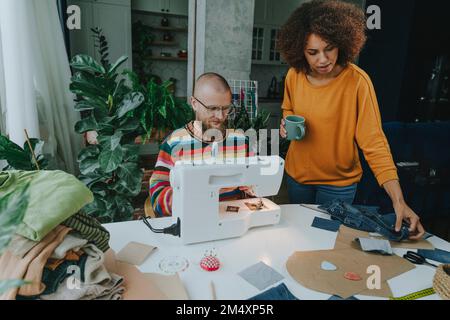 Young fashion designer with colleague working in workshop Stock Photo