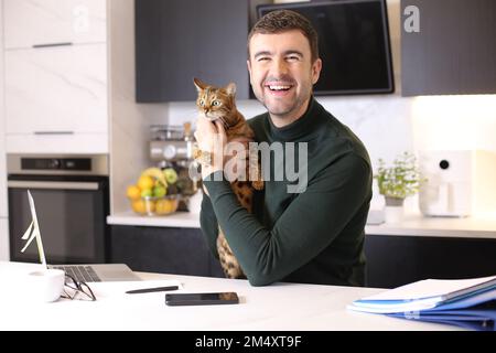 Attractive man working from home with his cat Stock Photo
