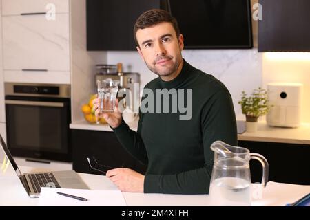 Businessman drinking water while working from home Stock Photo