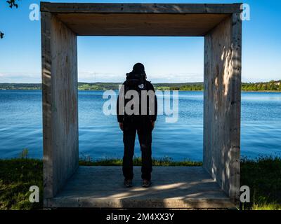 A pilgrim is looking at a huge lake that is placed outside of the Swedish city of Ostersund. The Scandinavian pilgrimage is known as 'St. Olavsleden', is a 580km route that goes from the Baltic Sea in the East to the Atlantic Ocean in the West, from Selånger in Sweden to Trondheim in Norway. Stock Photo