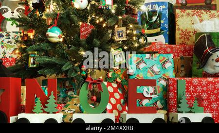 Presents cluttered under the Christmas tree on floor Stock Photo