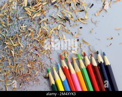 Colored pencils and shavings top view. Close-up drawing pencils. Pencils are sharpened with a clerical knife, drawing tools. Stock Photo