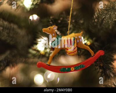 Rocking deer Christmas ornament hanging from tree. Stock Photo