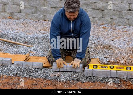 Construction workers for sidewalk consisting of stone concrete pavers Stock Photo