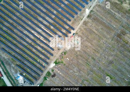 Aerial view of electrical power plant under construction with truck delivering assembly parts for solar panels on metal frame for producing electric Stock Photo