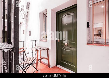 Hall of a house in patio de corrala with freshly painted door and bars on the windows Stock Photo