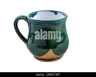 Curved ceramic cup. Mug green with handle made by hand. Pottery with glossy glaze. An empty green cup isolated on white Stock Photo