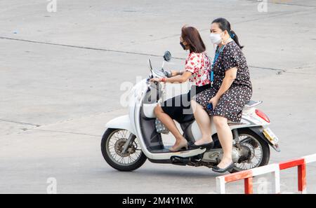 SAMUT PRAKAN, THAILAND, FEB 23 2022, Two women rides on motorcycle at the street. Stock Photo