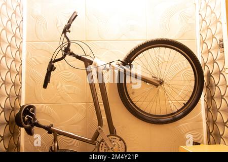 Bicycle mounted on the ceiling in a small residential apartment with limited space, bicycle storage at home, idea Stock Photo