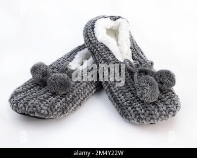 Home winter women's slippers on a white background. pair of fluffy fleece house shoe with pompoms. Gray rag soft closed slippers Stock Photo