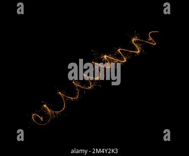 A spiral of sparklers on a black background. Festive fireworks and lights at night. Stock Photo