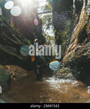 A vertical shot of a young guy standing in a canyon in the Blue Mountains, in Australia Stock Photo