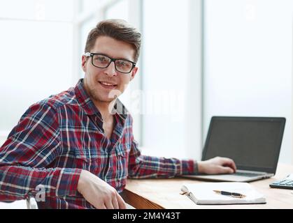 Young man with glasses working on his notebook, early in the morning, getting the business out of the way nice and early in the day Stock Photo