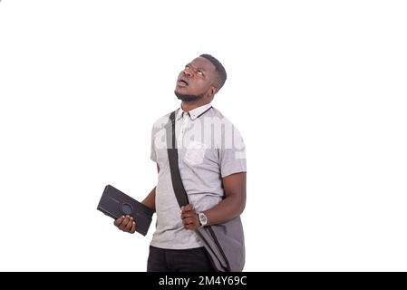 handsome worried young man carrying bag over shoulder and holding digital tablet while looking up. Stock Photo