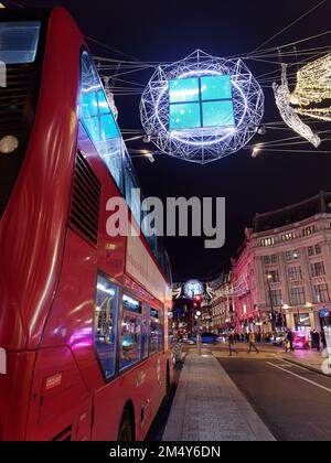 London bus and Spirits of Christmas aka Angels suspended above Regent Street as part of the Christmas Lights display. London Stock Photo