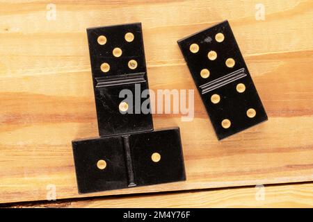 Three dominoes on a wooden table, macro, top view. Stock Photo