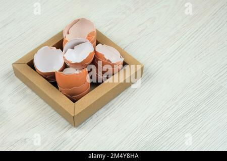 Pile of cracked broken eggshells on carton plate. Organic waste for compost. Copy space. Stock Photo