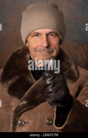 Older man in winter outfit, thumbs up Stock Photo