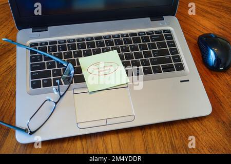 Modern laptop with sticky note to change password with mouse and glasses. Stock Photo