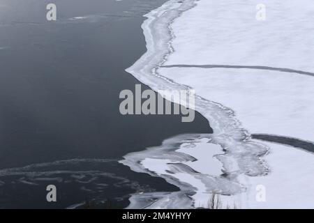 The beautiful view of Lake Sevan under a layer of ice in winter. Gegharkunik Province, Armenia. Stock Photo