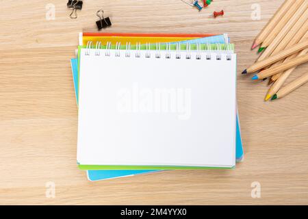Back to school concept. Top view photo of notepads, pens, sharpeners, ruler, staplers, clips, markers and erasers on wooden table Stock Photo