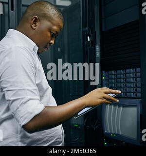 Smart technology for smart system administration. an IT technician using a digital tablet while working in a data center. Stock Photo