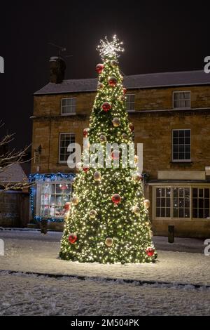 Christmas tree in the snow at night. Broadway, Cotswolds, Worcestershire, England Stock Photo